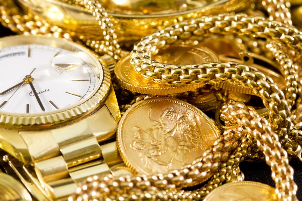 gold jewelry, watch and coins in a pile
