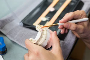 Technician painting a dental crown