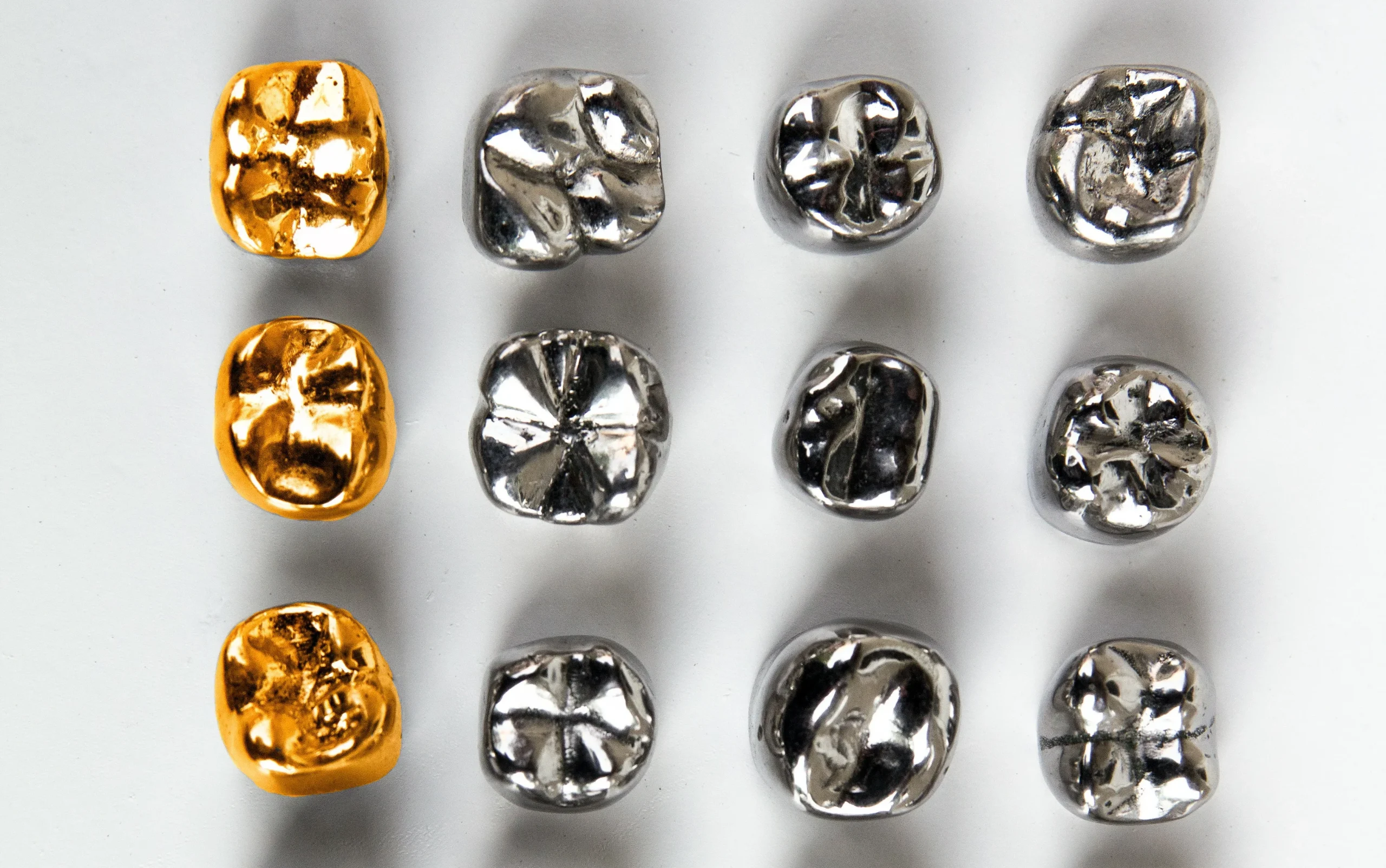 4 rows of 4 precious metal dental crowns