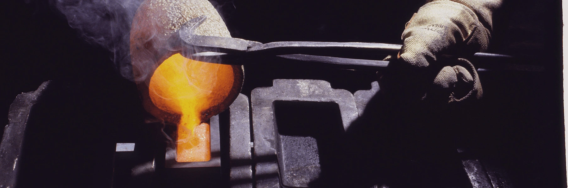 A precious metals refiner pours liquid gold from a crucible