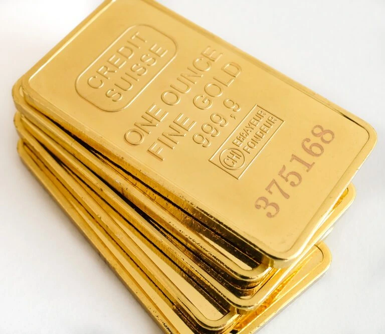 Stack of one ounce gold bars on white background