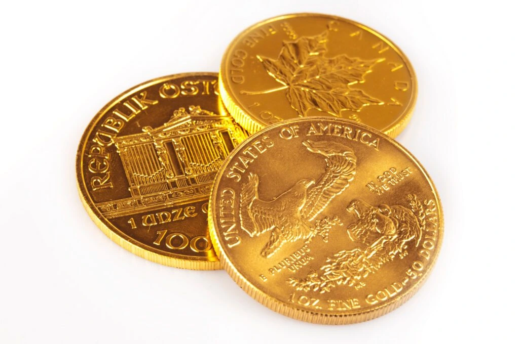 Three gold bullion coins on a white background
