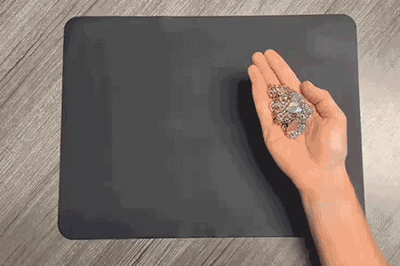 Gold and silver jewelry being placed on a mat for packing before shipment